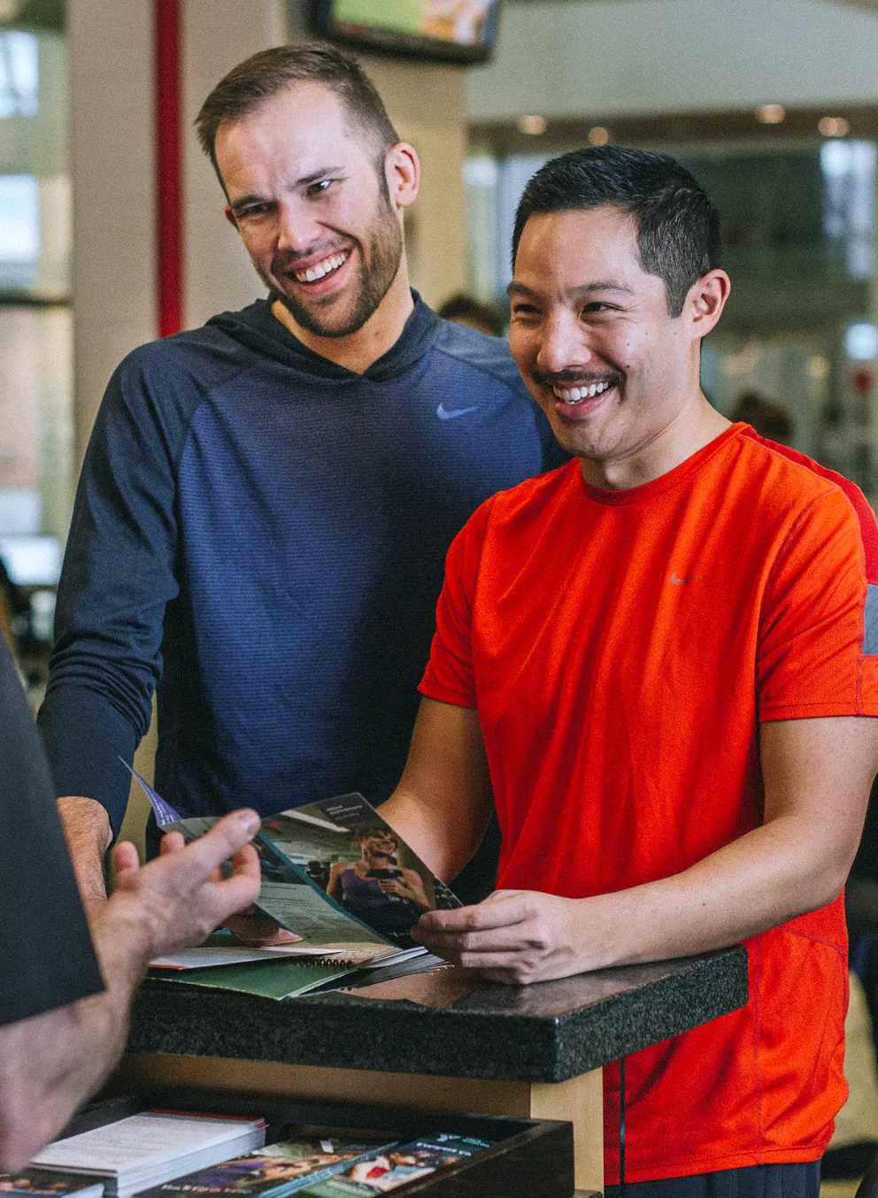 Staff helping YMCA members at the front desk