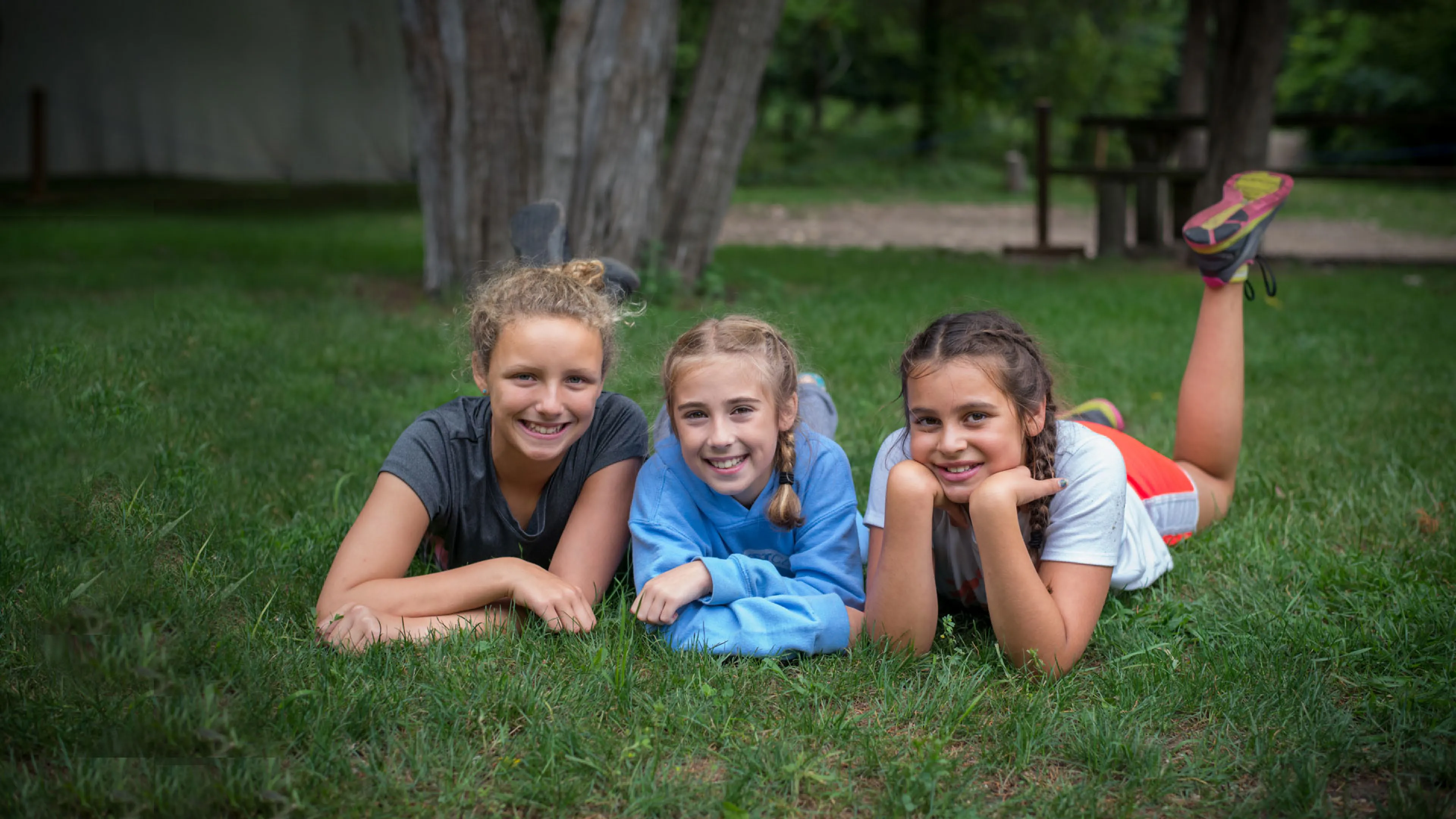 3 young women enjoying the grass.