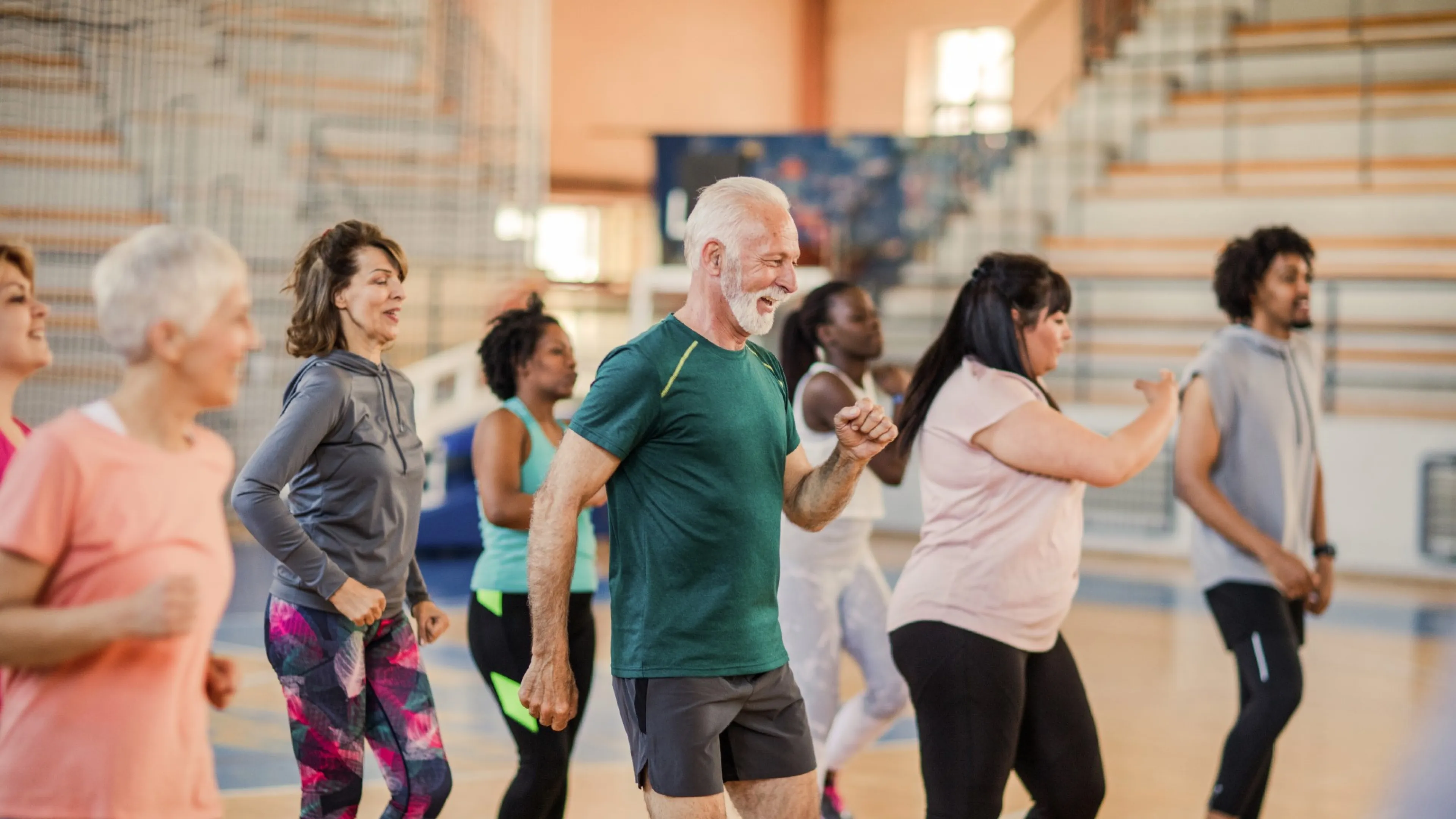 A diverse group of people participate in a fitness class at the Y.